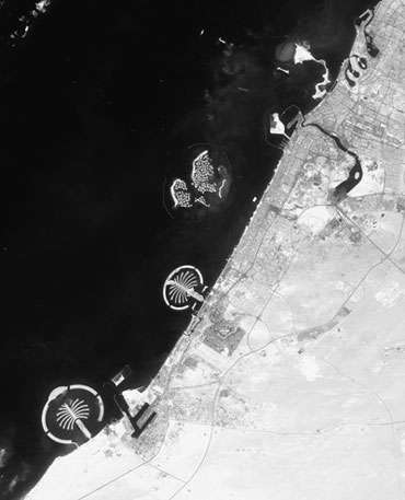 Космический снимок побережья Дубая. Хорошо видны уже сооруженные два пальмовых острова. К северу от них начинают вырисовываться очертания карты мира